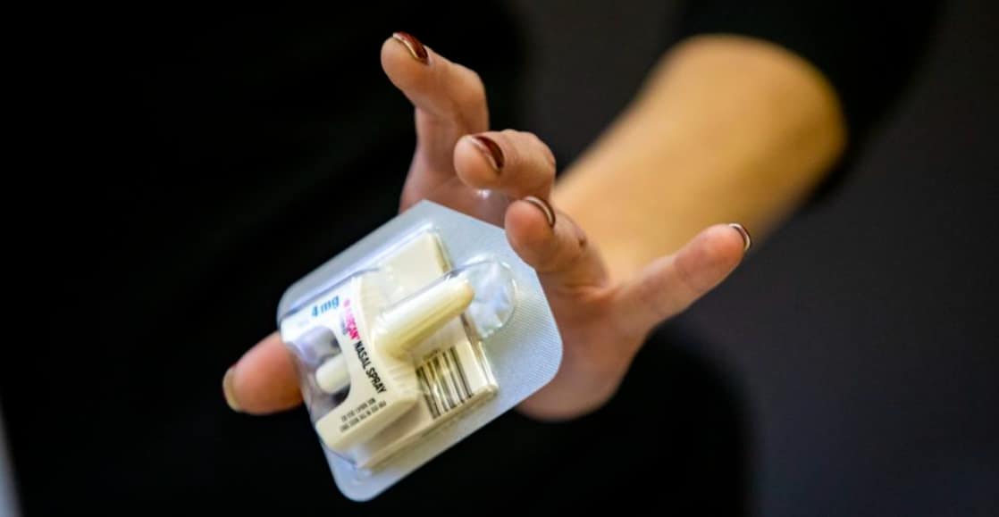 hand holding Naloxone inhaler