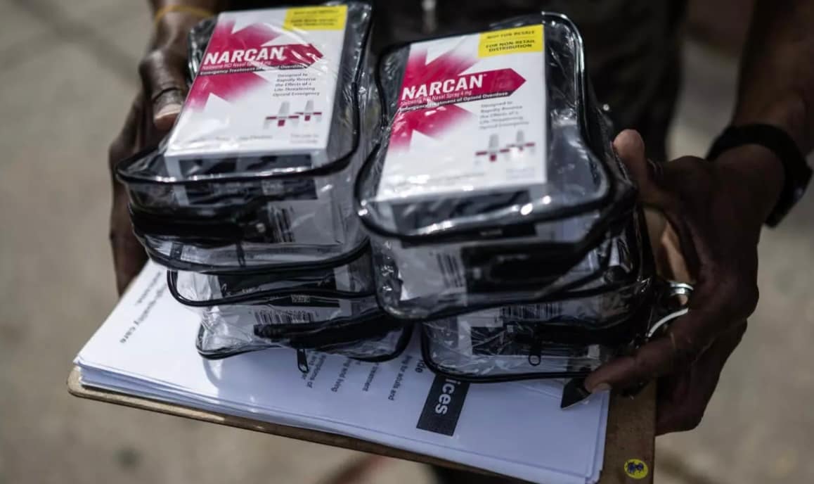 outreach worker holding boxes of Narcan to distribute
