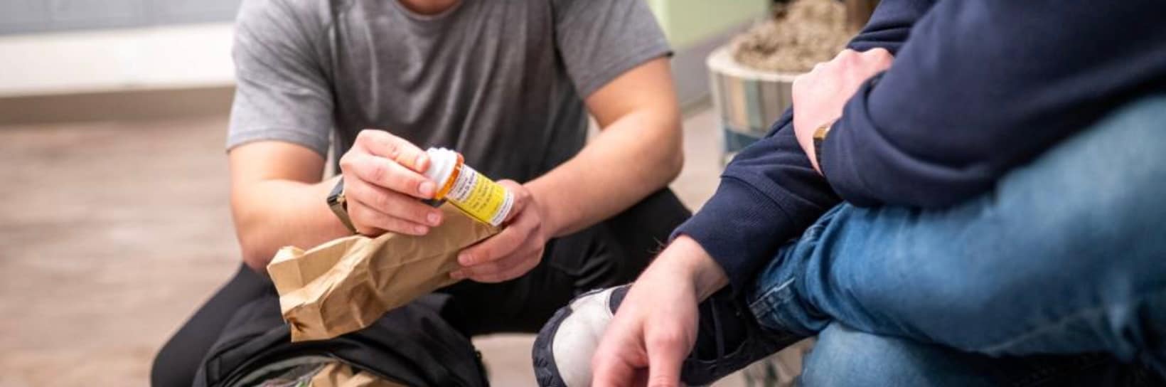 Medical professional handing a prescription drug container to someone