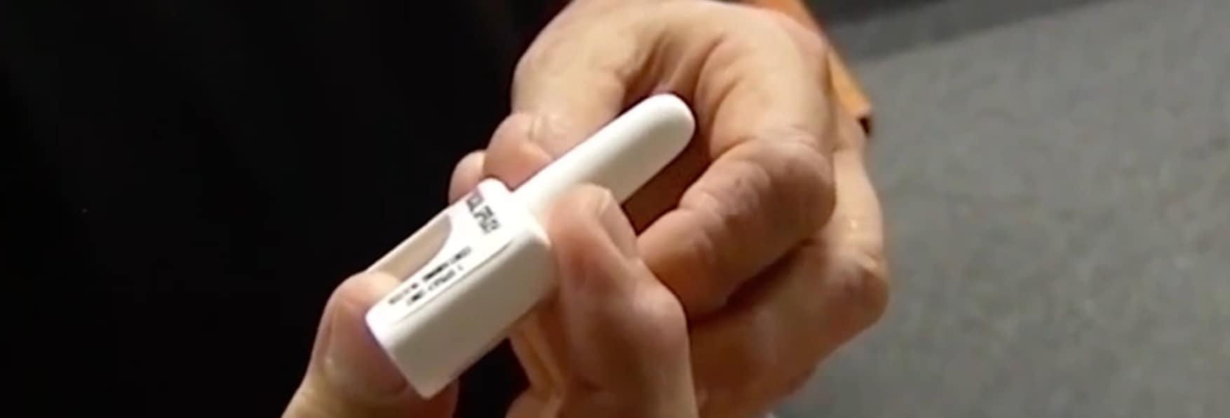 hands holding naloxone nasal applicator