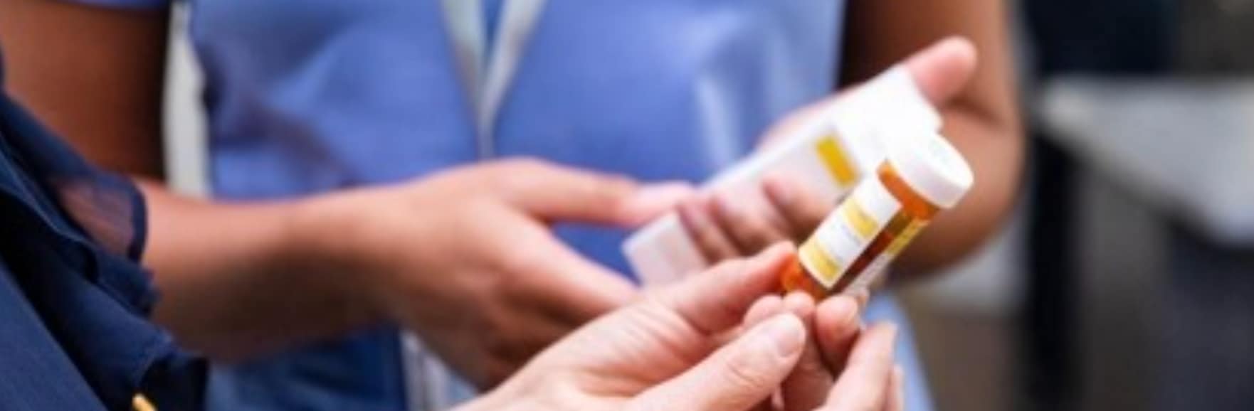 medical professional giving pills to a patient
