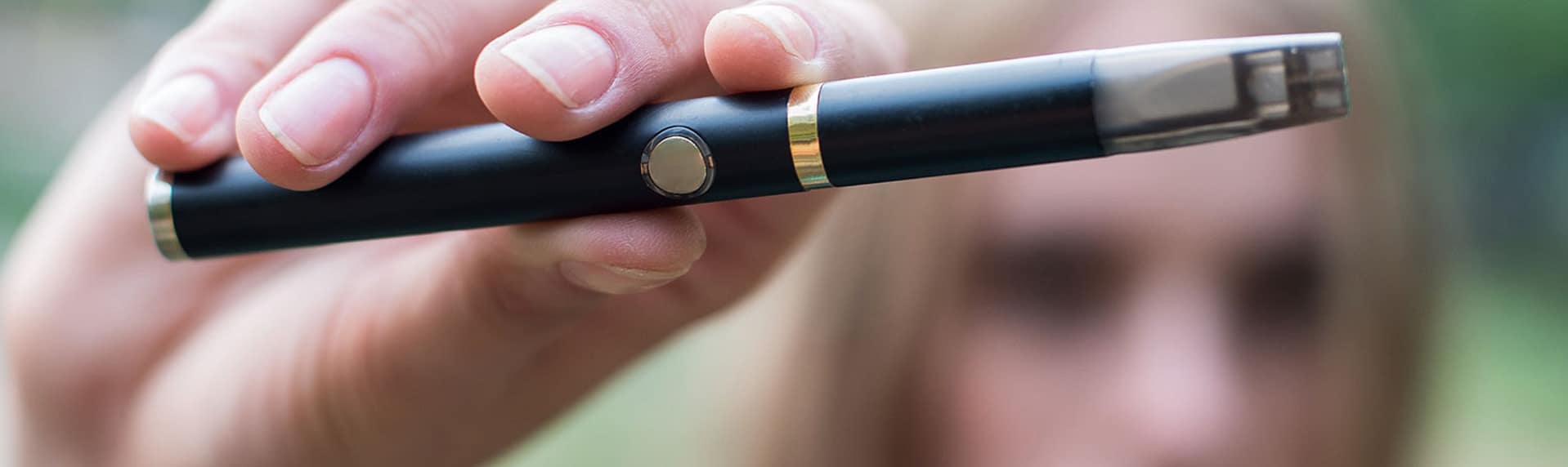 young girl holding a vape pen