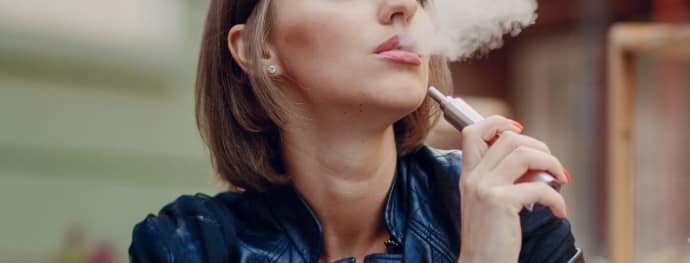Woman using Iqos vaping device