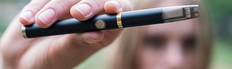 young girl holding a vape pen