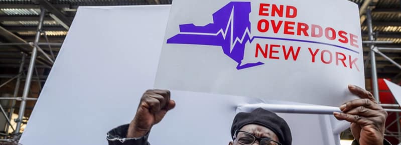 Man holding sign to reduce overdoses in New York