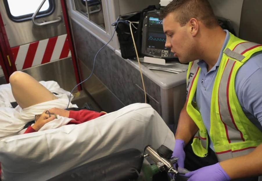 emergency responder with a patient in an ambulance