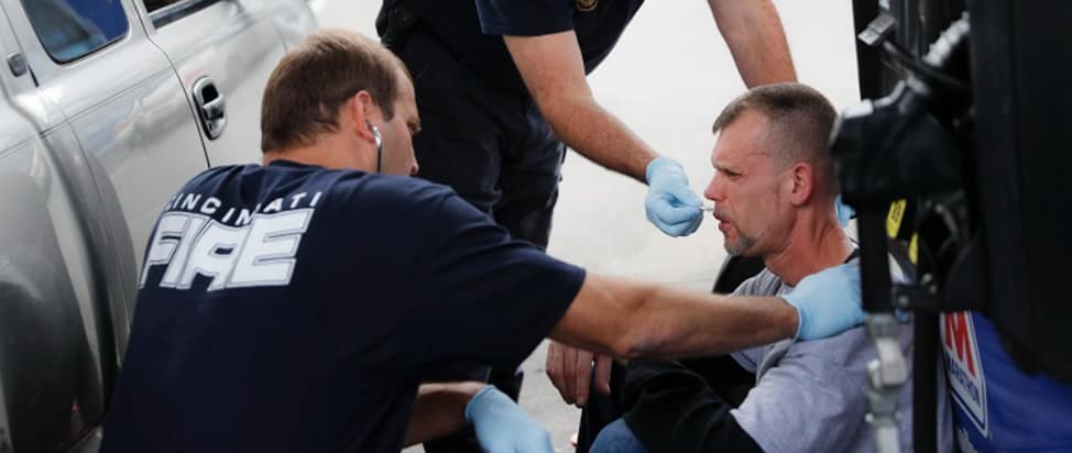 Paramedics helping a man sitting