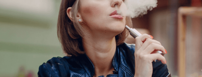 Woman using Iqos vaping device