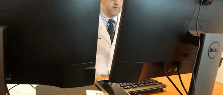 medical professional behind computer monitors