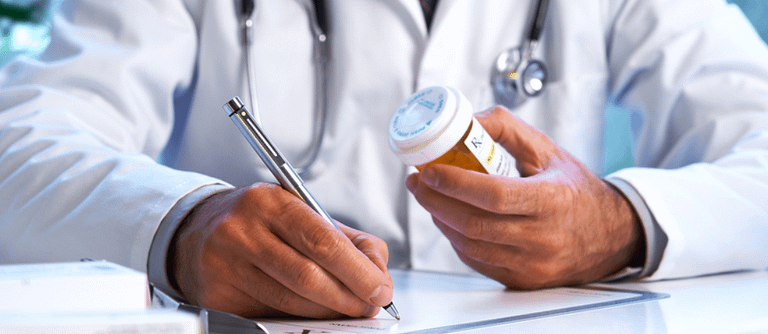 Doctor writing prescription for pills