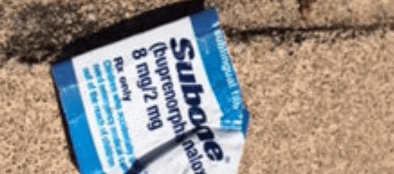 an opened suboxone package on the sidewalk