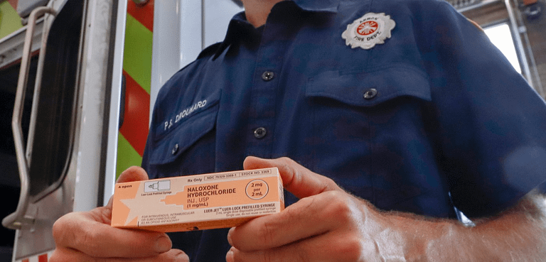 first responder holding naloxone