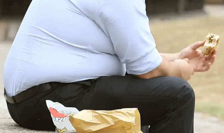 obese adult eating fast food