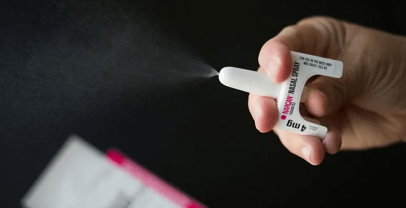 Hand holding Narcan nasal spray