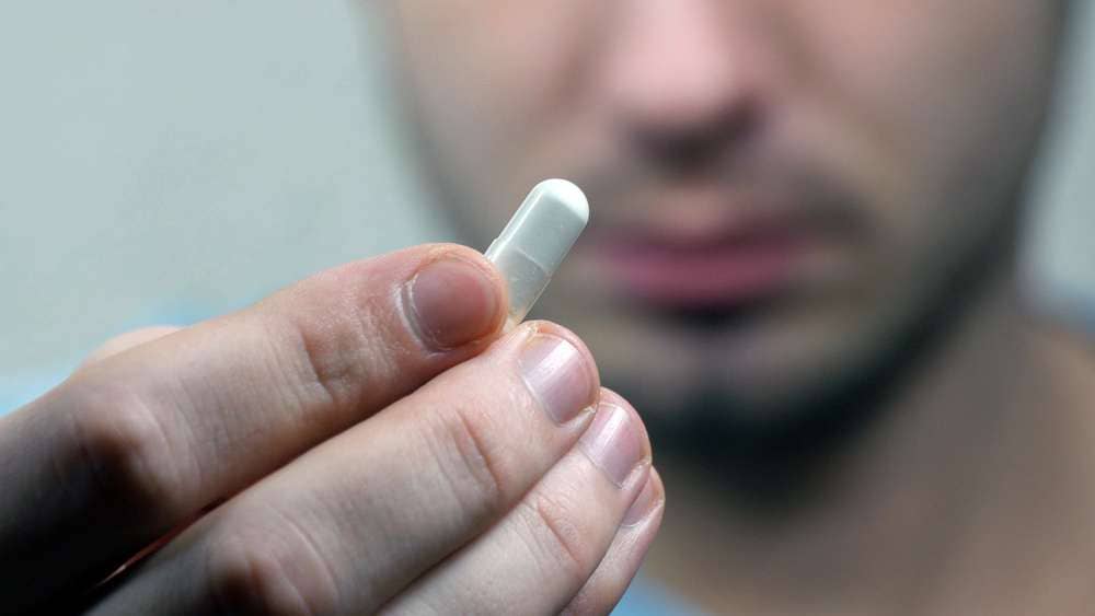 man holding pill