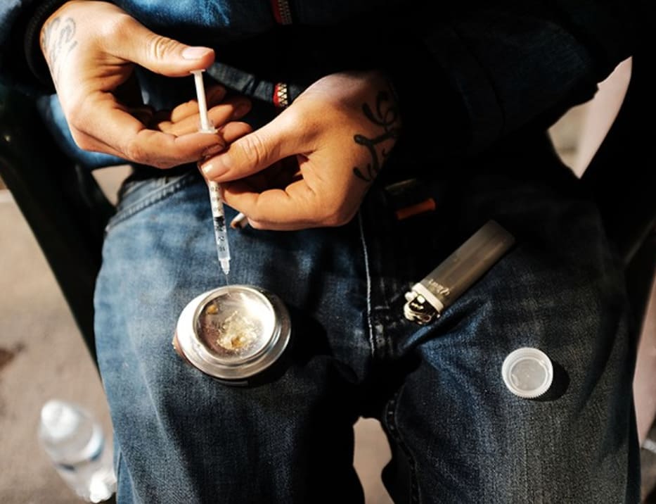 man preparing to inject drugs